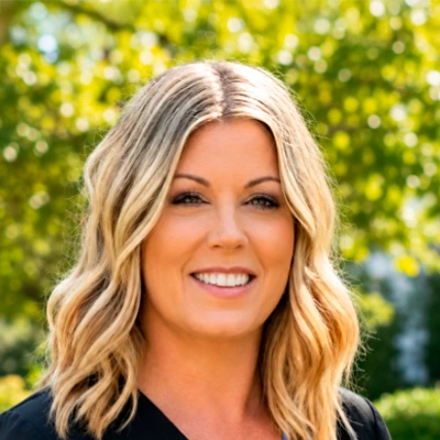 Close-up outdoor portrait of a person with shoulder-length wavy hair