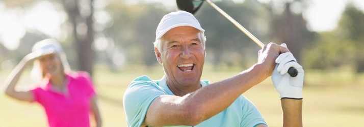 Person holding a golf club mid-swing
